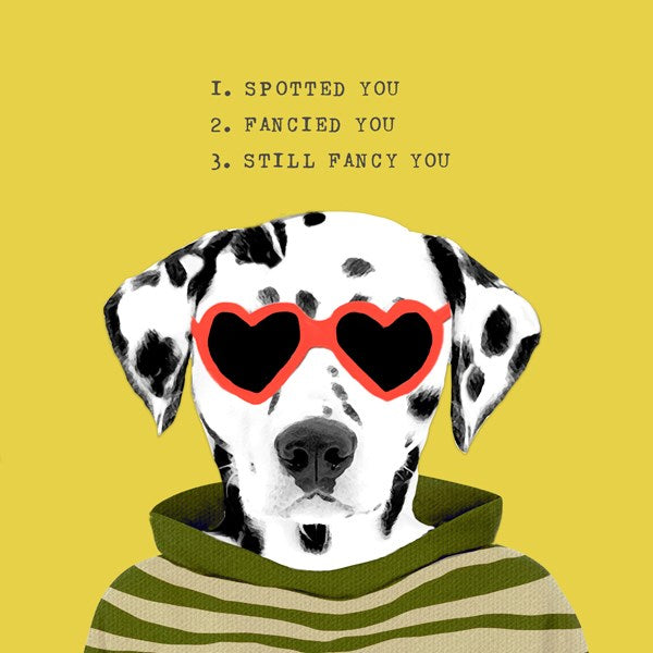 Dalmatian wearing red heart shaped glasses.