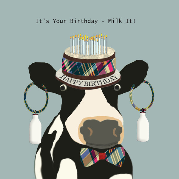 Cow wearing a birthday cake hat and milk bottle ear rings.